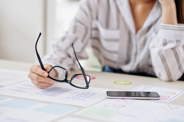 Bezimienny Strzał Kobiety Posiadający Nowoczesne Czarne Okulary Siedzący Przy Biurku — Zdjęcie stockowe