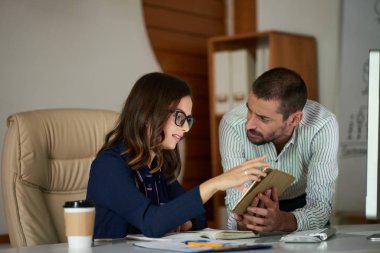 İşadamı kadın iş arkadaşı ile tablet bilgisayarda bilgi tartışıyor