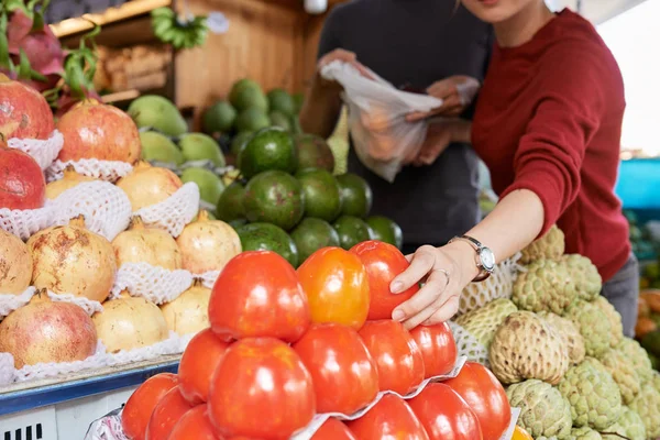 市場で熟した美味しい柿を買うカップルのクローズアップ画像 — ストック写真