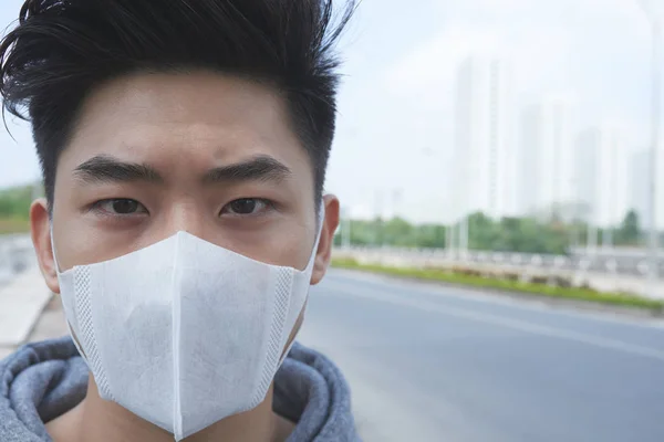 越南年轻人在户外行走时戴防护面具的脸 — 图库照片