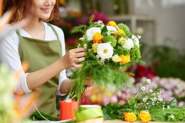 Close-up image of female florist making beautiful bouquet of fresh flowers clipart