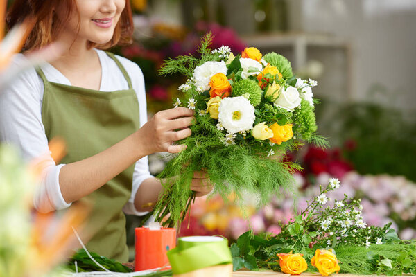 Close-up image of female florist making beautiful bouquet of fresh flowers