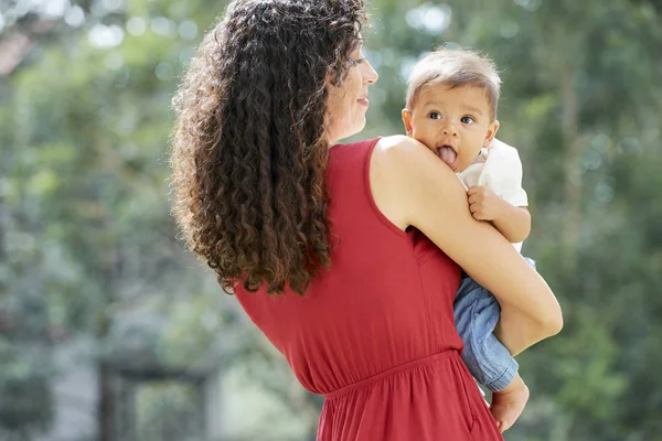 Visão Traseira Mulher Com Cabelos Longos Encaracolados Segurando Seu Filho — Fotografia de Stock