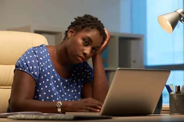相当严重的非洲裔女商人在笔记本电脑屏幕上阅读报告 — 图库照片