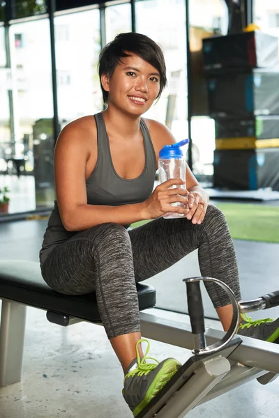 Portret Van Jonge Vrouw Zittend Sportuitrusting Met Fles Water Glimlachend — Stockfoto