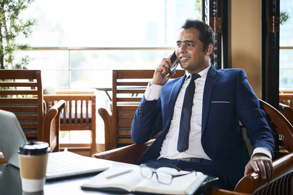 自信に満ちた成熟したビジネスマンは カフェの椅子に座って携帯電話で話し 笑顔で — ストック写真