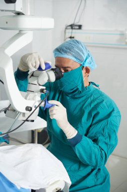 Ameliyathanede lazer görme düzeltme işletim sistemi ile çalışan üniformalı cerrah 