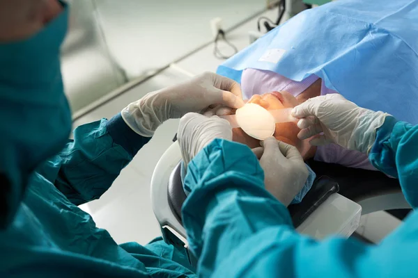 Vrouwelijke Patiënt Liggend Operatiekamer Terwijl Team Van Chirurgen Beschermende Handschoenen — Stockfoto