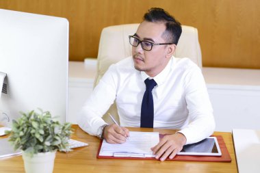 Bilgisayar monitörü ve dolum belgesi nde Vietnamlı işletme yöneticisi okuma bilgileri