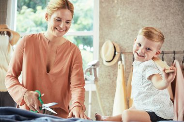 Mutlu güzel genç kadın oğlu cetvel ile oynarken kumaş kesme