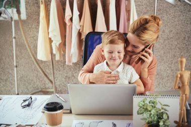 Küçük oğlu ile tasarım stüdyosunda çalışan genç anne