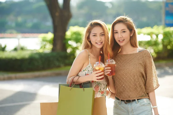 一日中買い物をした後にアイスティーを飲む2人の魅力的なアジアの女性 — ストック写真