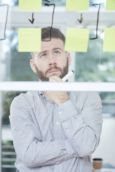 Pensive Bebaarde Zakenman Staande Kijkend Naar Business Strategie Glazen Wand — Stockfoto