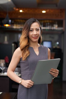 Elinde klasör ile oldukça gülümseyen restoran sahibinin Portresi