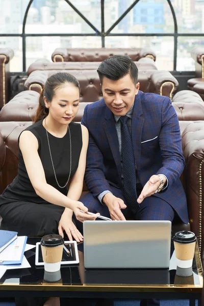 Ludzie Biznesowi Siedzący Kanapie Wskazując Laptopa Pracy Nad Prezentacji Online — Zdjęcie stockowe