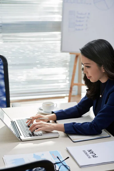 Unga Kontorsarbetare Sitter Arbetsplatsen Och Skriva Bärbar Dator Hon Förbereder — Stockfoto