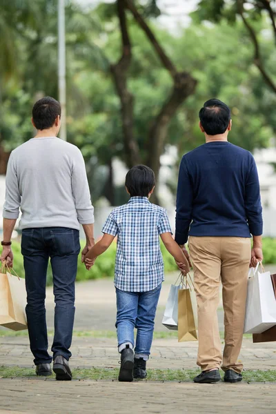 Visão Traseira Menino Dois Homens Roupas Casuais Carregando Sacos Papel — Fotografia de Stock