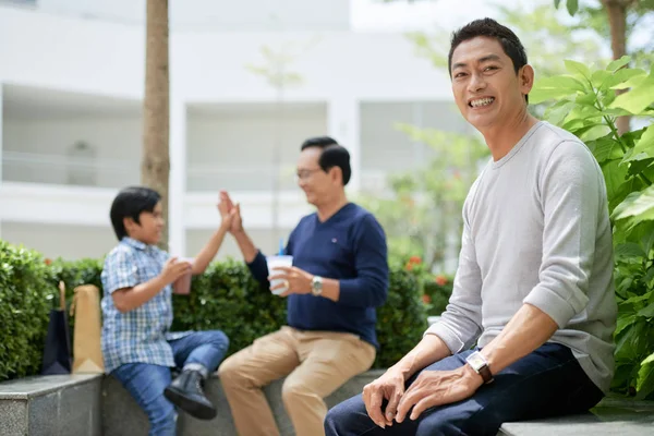 Bonito Asiático Cara Sorrindo Olhando Para Câmera Enquanto Sentado Fronteira — Fotografia de Stock