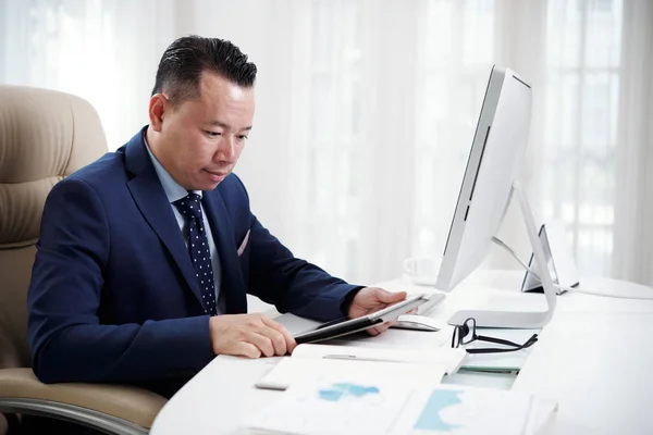 Asiatischer Manager Sitzt Tisch Und Schaut Mit Ernstem Gesichtsausdruck Online — Stockfoto