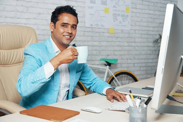 Retrato Funcionário Sorridente Sentado Mesa Bebendo Café Enquanto Trabalhava Computador — Fotografia de Stock