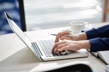 Ofiste dizüstü bilgisayarda online çalışan işyerinde oturan ofis çalışanının yakın çekim