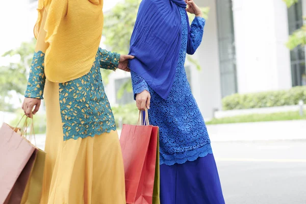 穿着穆斯林服装的女性朋友在购物后带着纸袋在户外散步 — 图库照片
