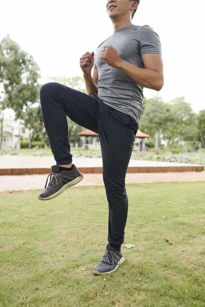 Gülümseyen Genç Koşucu Eğitim Öncesi Isınmak Için Yüksek Diz Egzersiz — Stok fotoğraf