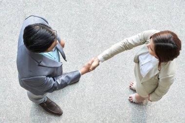 Ayakta ve el sıkışarak genç iş ortaklarının yüksek görüntü, onlar ofiste birbirlerini selamlıyorum