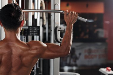 Uçan makinede ağırlık kaldıran sporcu, arkadan görüntüle