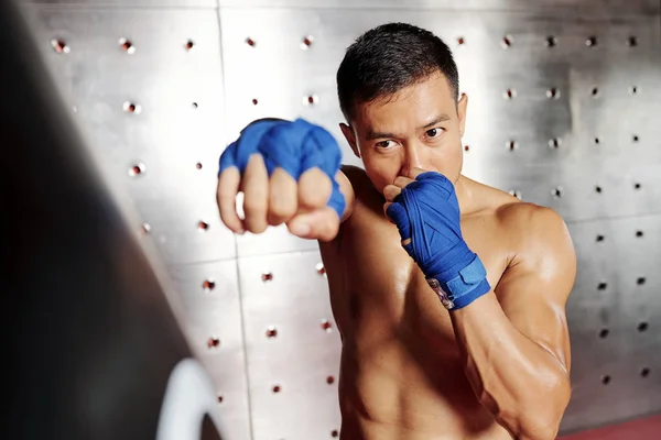 ヘルスクラブでパンチバッグを持つ若いアジアのボクサーのトレーニング — ストック写真