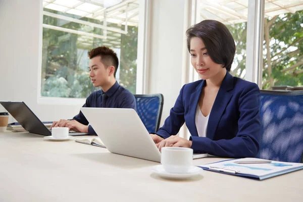 亚洲商务人士坐在桌旁 在笔记本电脑上打字 他们在办公室工作期间在线工作 与客户沟通 — 图库照片