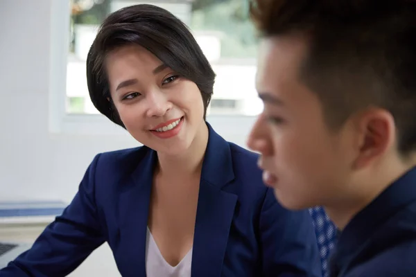 Asiática Joven Mujer Negocios Sentado Oficina Hablando Con Colega Sonriendo — Foto de Stock