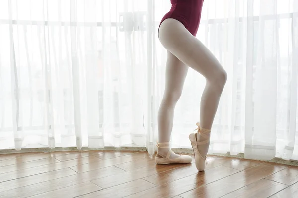 优雅苗条的芭蕾舞演员穿着尖鞋和绑腿在芭蕾学校对窗户锻炼的特写 — 图库照片