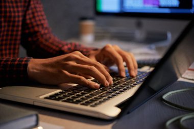 Gece geç saatlerde karanlık ofiste çalışan programcının elleri