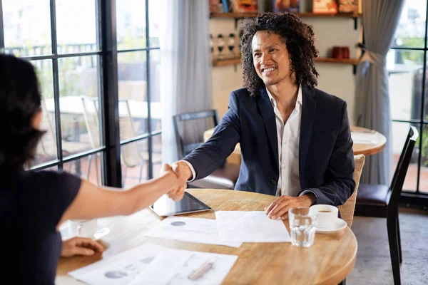 論文を議論する前に 彼の女性の同僚の手を握る幸せな混合人種のビジネスマン — ストック写真