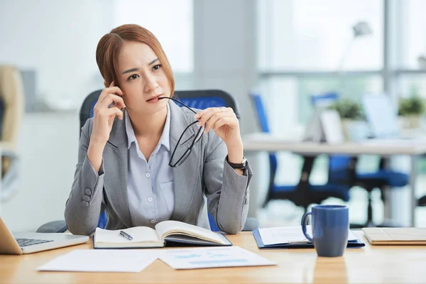 Unga Fundersam Affärskvinna Sitter Kontoret Skrivbord Med Anteckningsblock Och Funderar — Stockfoto