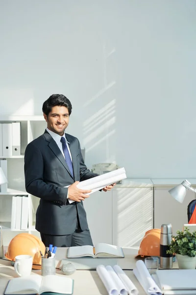 Porträt Eines Jungen Indischen Ingenieurs Der Mit Bauplänen Tisch Steht — Stockfoto