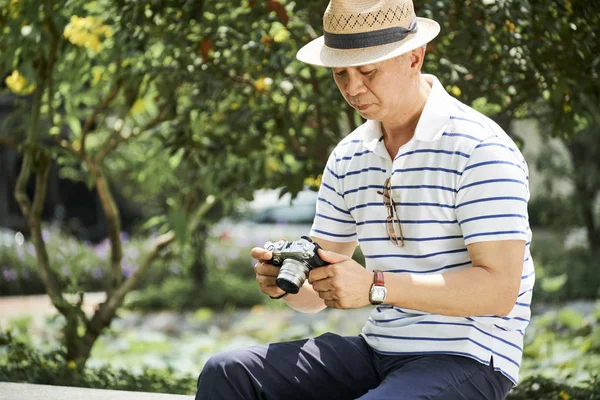 Senior Mann Mit Hut Sitzt Auf Bank Park Und Sieht — Stockfoto