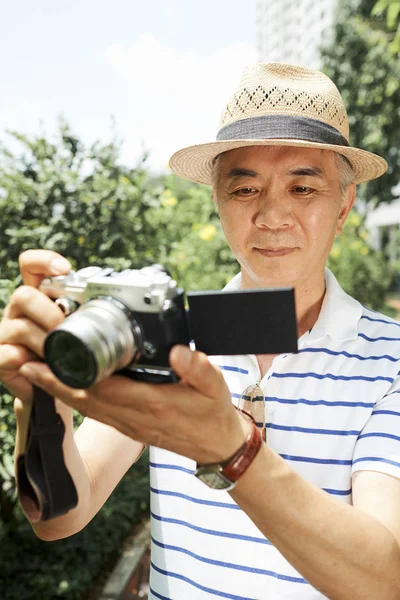 Asyalı Üst Düzey Fotoğrafçı Dijital Kamera Tutan Arka Planda Yeşil — Stok fotoğraf