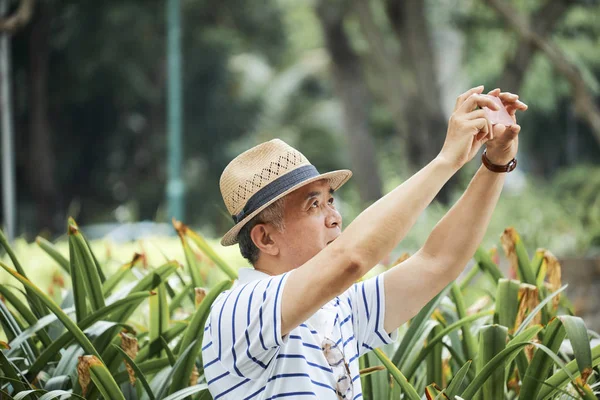 Hombre Mayor Con Sombrero Sosteniendo Teléfono Móvil Haciendo Retrato Selfie —  Fotos de Stock