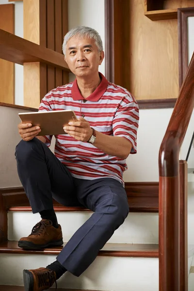 Merdivende Oturan Evinde Dijital Tablet Kullanarak Rahat Giyim Asyalı Olgun — Stok fotoğraf