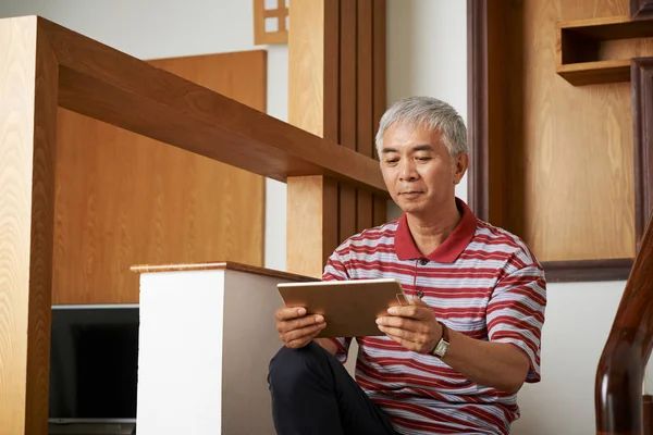 Asiático Hombre Mayor Sentado Escalera Casa Moderna Viendo Algo Tableta —  Fotos de Stock