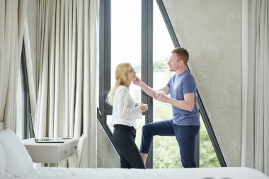 Kız arkadaşının yanak dokunmadan kahve fincan ile yakışıklı genç adam