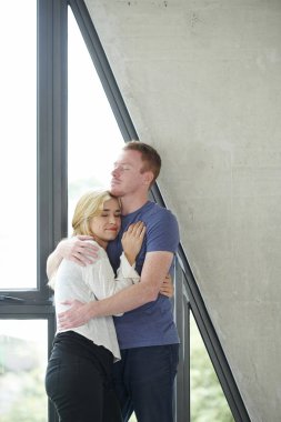 Sakin mutlu genç çift sevgi ve şefkat ile birbirlerine sarılma