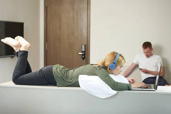 Wanita Muda Yang Pensif Dalam Pemrograman Headphone Pada Laptop Pacar — Stok Foto