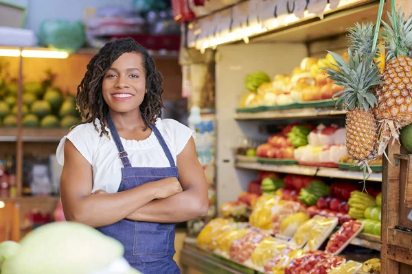 彼女の腕を組んで食料品店に立っているかわいい笑顔の黒人セールスウーマンの肖像画 — ストック写真