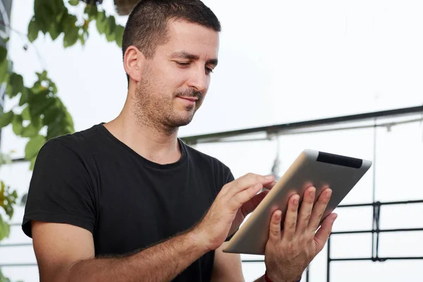 Młody Mężczyzna Trzyma Tablet Cyfrowy Dotyka Wyświetlacza Który Komunikuje Się — Zdjęcie stockowe