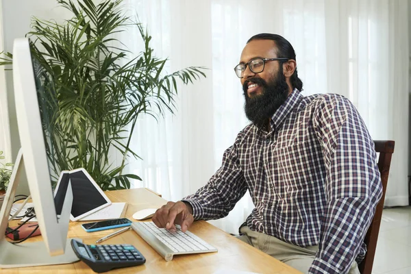 Empresario Barbudo Con Anteojos Sentado Mesa Frente Monitor Computadora Riendo — Foto de Stock