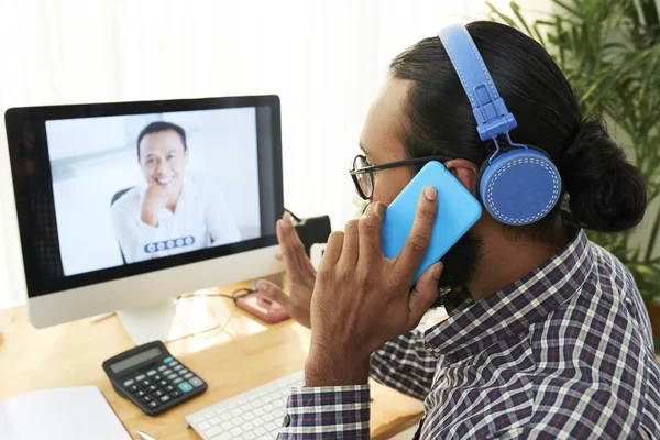 헤드폰에 아프리카 사업가는 동료와 온라인 회의를 가지고 사무실에서 전화로 이야기하는 — 스톡 사진