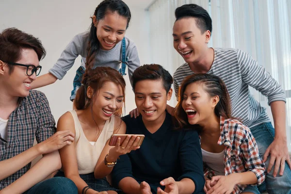 Grupo Alegres Jóvenes Riendo Mirando Pantalla Del Smartphone Casa —  Fotos de Stock